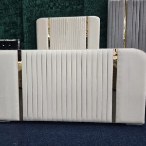 Cream velvet bed with gold accents and vertical panel headboard