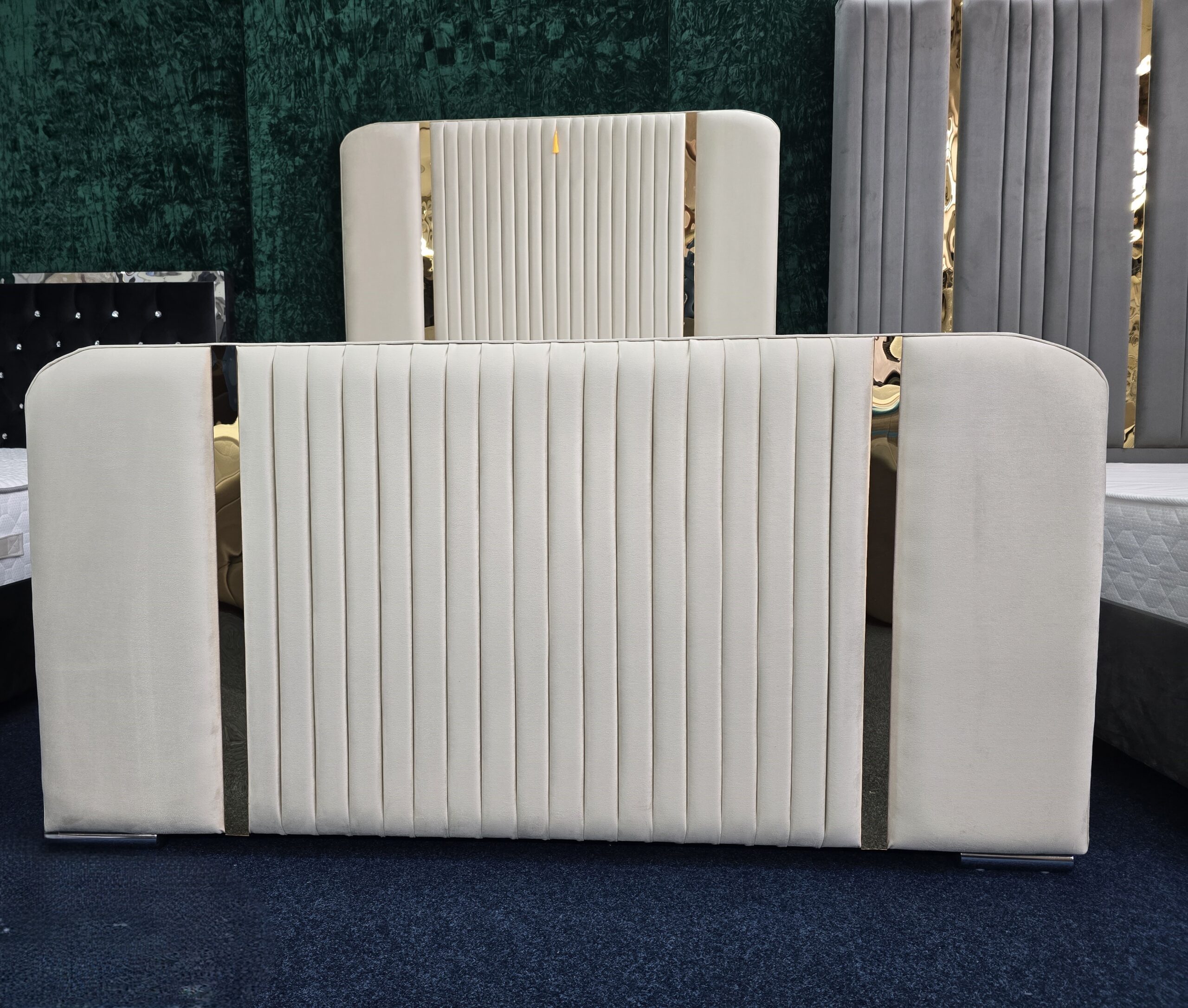 Cream velvet bed with gold accents and vertical panel headboard