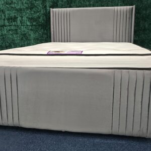 : Grey velvet bed with vertical panel headboard and padded design