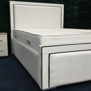 Side view of modern white padded bed frame with chrome accents