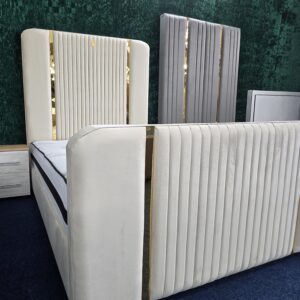 Bedroom setup featuring cream velvet bed with gold vertical panels by ZAK Furniture
