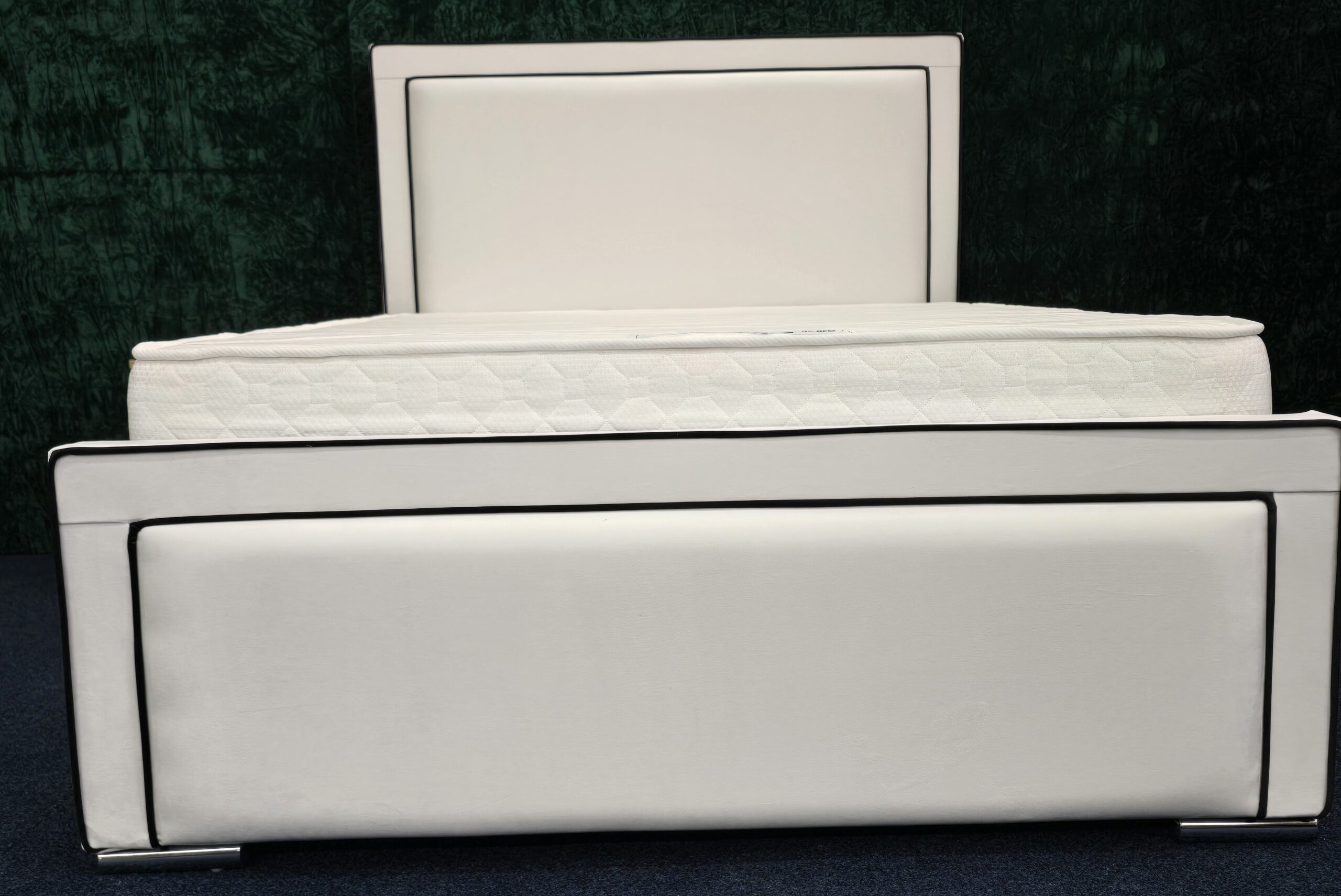 Modern white padded bed frame with chrome trim and faux leather finish by ZAK Furniture